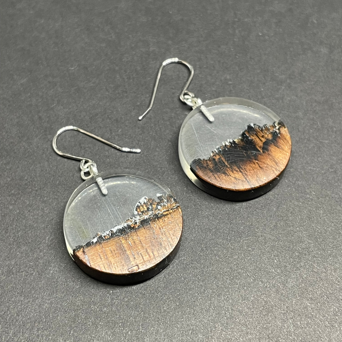 Handmade earrings made from live edge burnt walnut wood with clear resin.