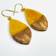 Handmade jewelry in  Minnesota. Made with maple wood and golden honey resin, pod shaped earrings.