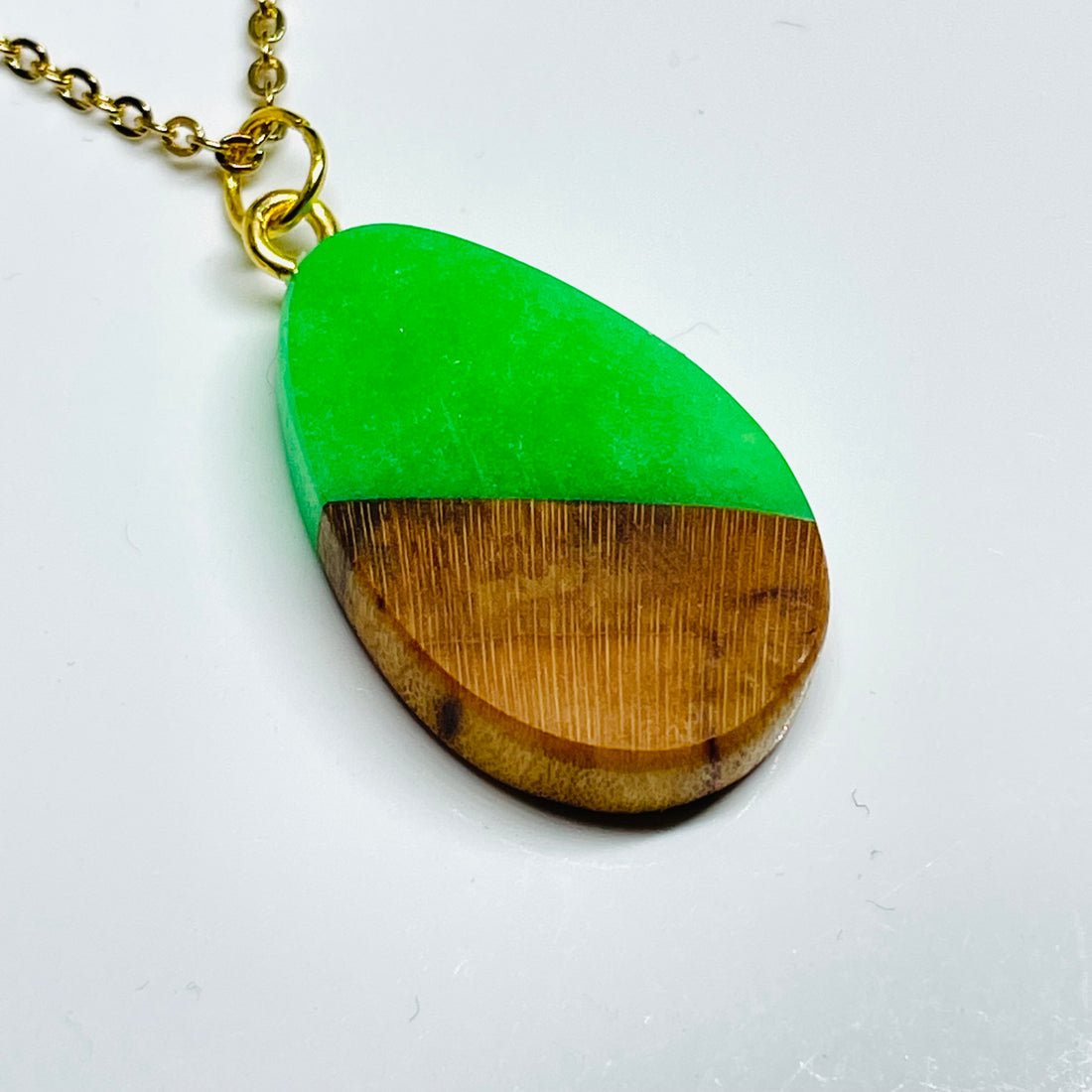handmade jewelry, Minnesota local wood and resin artist. handmade white oak wood and green glow-in-the-dark resin pendant necklace, 9" stainless steel gold colored chain.