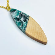 handmade jewelry, Minnesota local wood and resin artist. Dark green, black and white swirled e resin with maple wood, stainless steel gold colored 15" chain, large sliver surfboard shaped