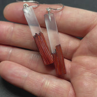 Earrings handmade with clear resin and live edge, burnt African padauk wood, shaped in straight plank stems.